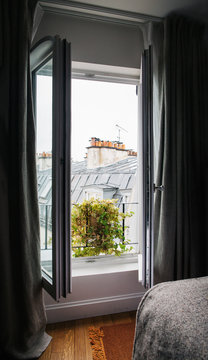 View on Paris Rooftops Through Open Hotel Window