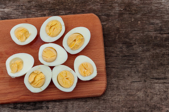 Boiled eggs on cutting board on wooden table