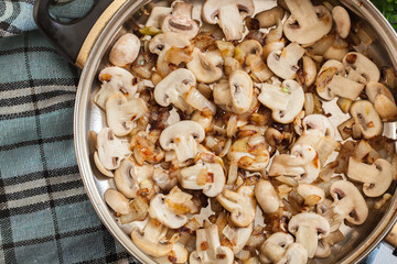 Mushrooms and onion on a fried pan