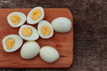 Boiled eggs on cutting board on wooden table