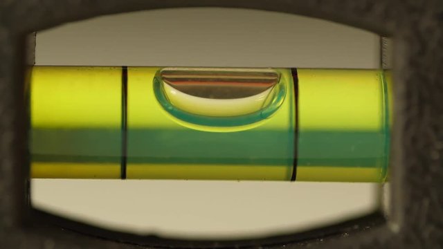 Carpenter's spirit level close up. Measuring the flatness with a spirit level. Level bubble up macro
