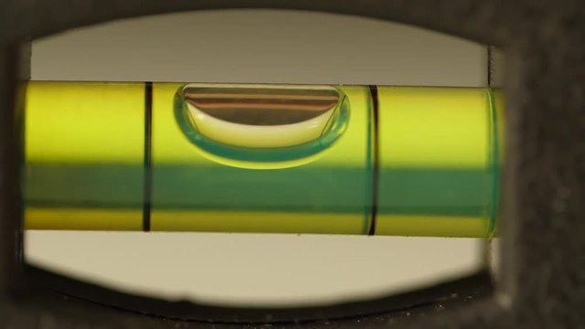 Carpenter's spirit level close up. Measuring the flatness with a spirit level. Level bubble up macro
