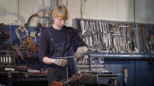 Mechanic is working with an engine of the car.