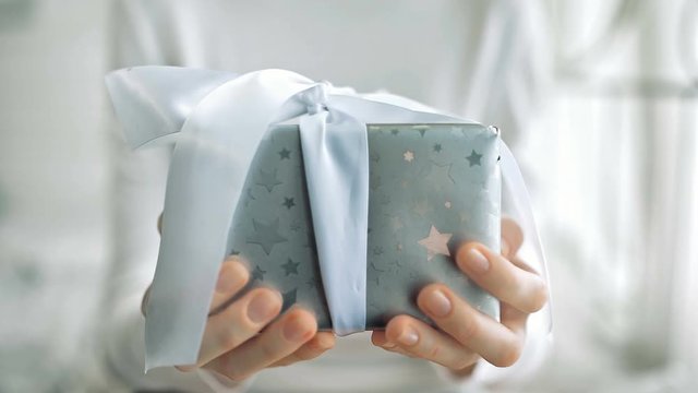 Young woman hands holding gift box