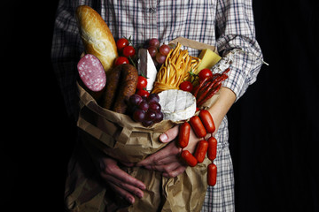 девушка держит  большой пакет с продуктами