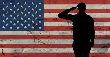 Silhouette soldier against background an old stone wall with flag of the USA