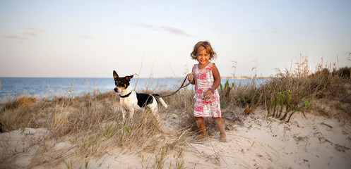 little girl with a dog on the beach