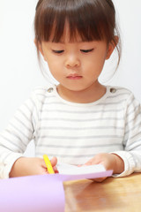 はさみで紙を切る幼児(3歳児)