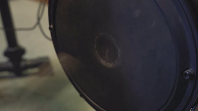 Electric bass drum pedal kicking the bass drum.