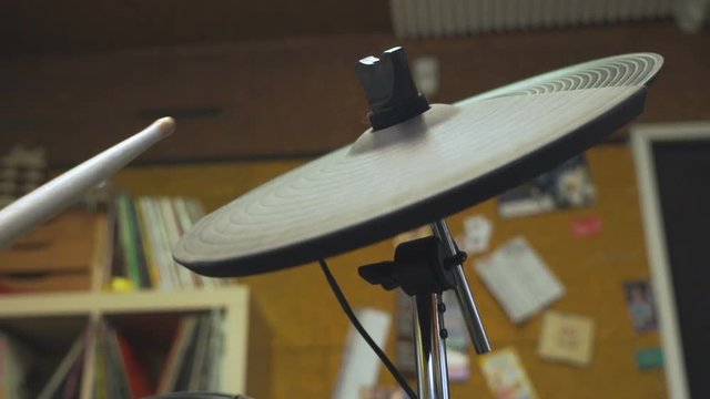Drum sticks beating on an electric crash cymbal.