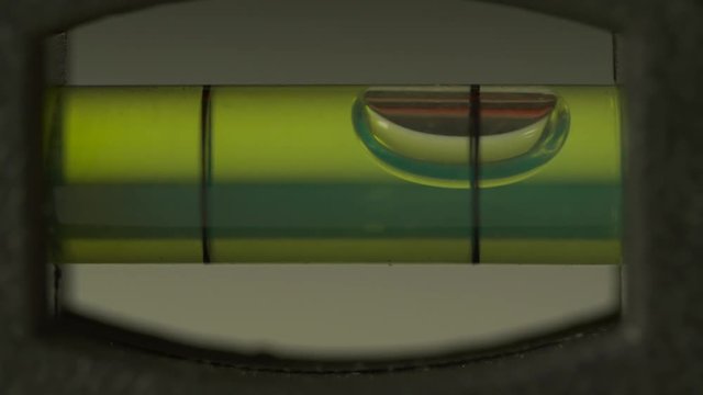 Carpenter's spirit level close up. Measuring the flatness with a spirit level. Level bubble up macro