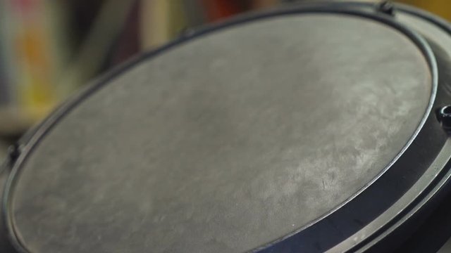 Drum sticks beating on an electric floor tom.