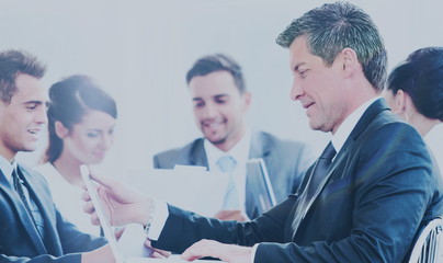 Happy businessman using laptop in business building, smiling.