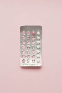 Contraceptive pills blister over pink background