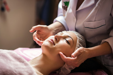Obraz na płótnie Canvas calm girl having spa facial massage in luxurious beauty salon