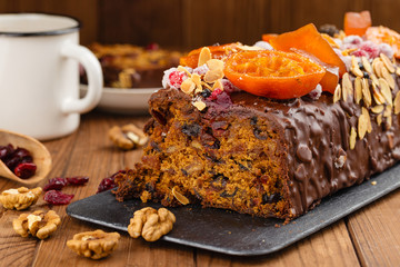 Cut traditional christmas fruit cake pudding in chocolate glaze