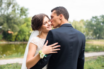 Beautifull wedding couple kissing and embracing outdoor. One beautiful wedding day