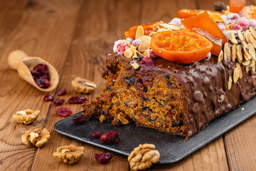 Cut traditional christmas fruit cake pudding in chocolate glaze