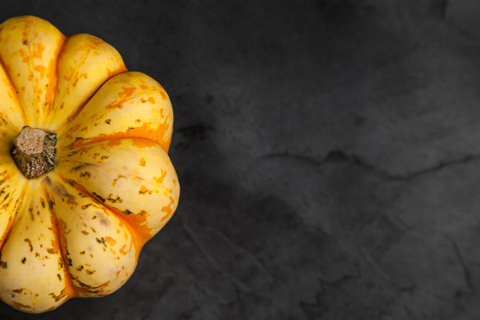Orange and Yellow Sweet Dumpling Squash on slate background with copy space