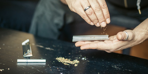 Obraz premium Preparing and rolling marijuana cannabis joint. Drugs narcotic concept