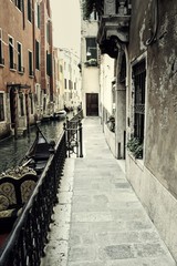 An empty path in Venice along a canal.