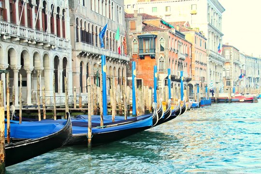 Moored gondolas in a row on the Grand Canal in Venice Italy.