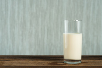 milk in a glass on wooden table background. a glass of cow milk. healthy drink concept