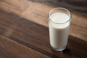 milk in a glass on wooden table background. a glass of cow milk. healthy drink concept