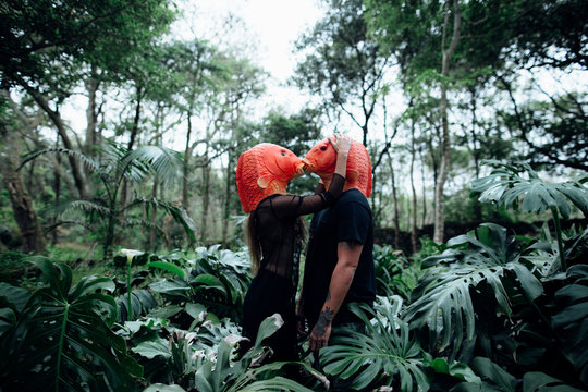 couple with orange fish masks on a rainforest