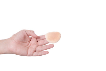 Hand holding round brown face sponge, cotton puff for cosmetic