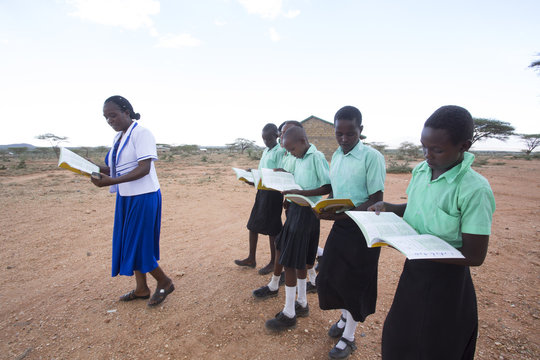 Teacher teaching students outdoors