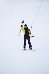 Happy skier using T-bar ski drag lift