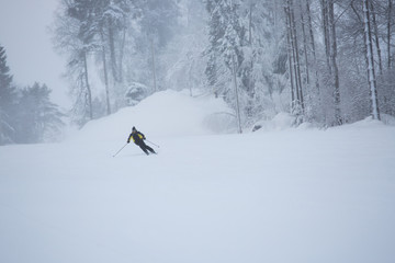 Skier on piste running downhill