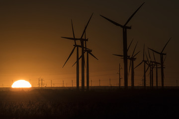 Sunrise behind a field of windmills 