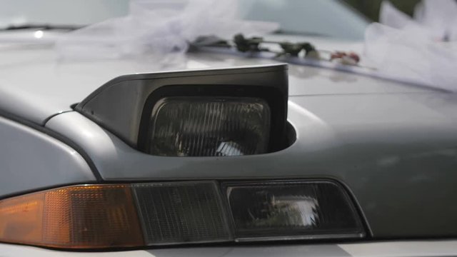 Car headlight turning on closeup