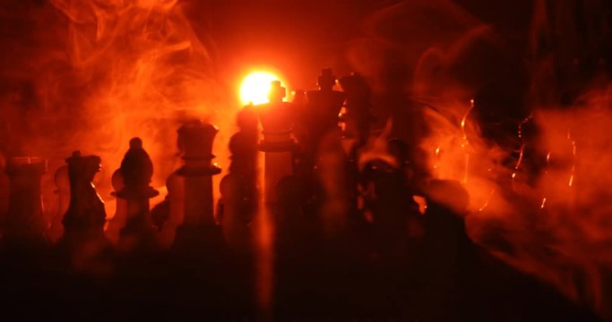 Chess board game concept of business ideas and competition and strategy ideas concept. Chess figures on a dark background with smoke and fog. Selective focus