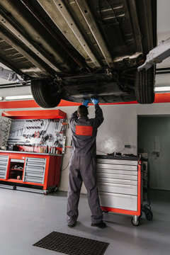 Mechanic working on car in garage/workshop