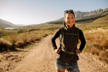 Smiling young woman hiking with backpack