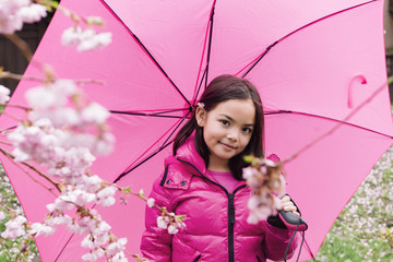 Portrait of cute girl with pink umbrella