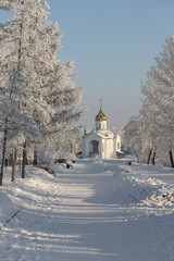 Winter landscape. Alley in the park leading to the Orthodox Chur