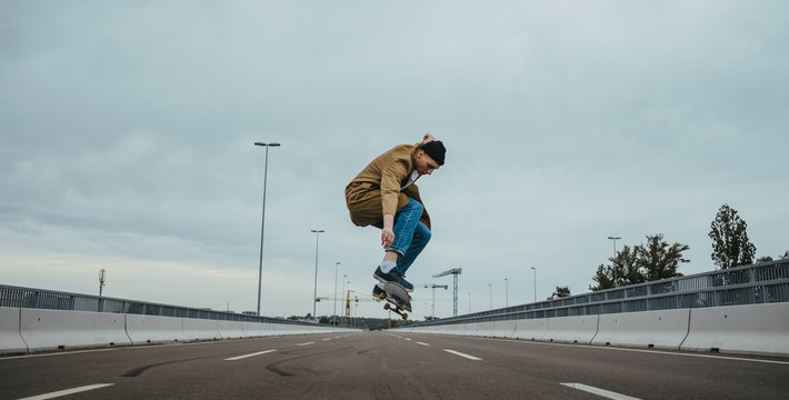 Young authentic urban adolescent/skateboarder on the streets doing tricks.