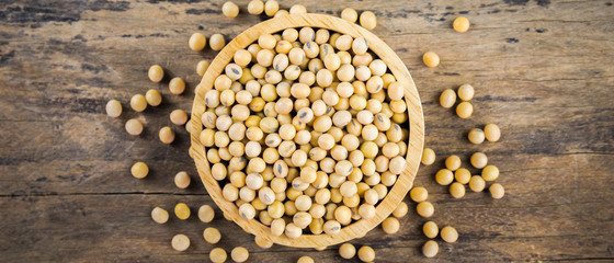 Soybean in wood bowl on wooden background.