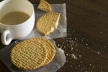 Coffee and biscuit or cracker leftover on messy table top.