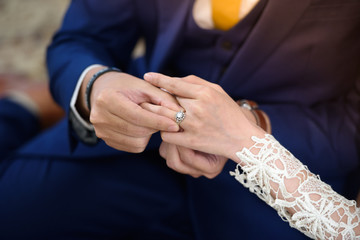The groom is wearing a bridal ring.