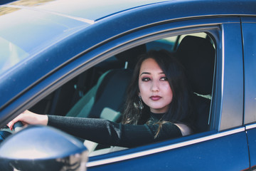 Fototapeta na wymiar Confident woman driving dark car