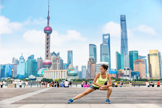 Running runner woman stretching legs in urban city