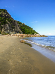 Secluded beach in Hua Hin, Thailand. Mountain and blue sky in the background.