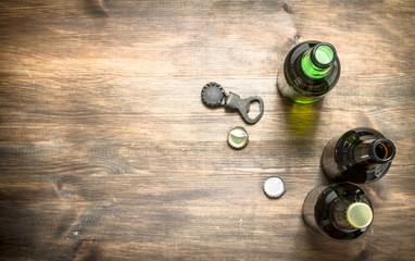 Bottles with fresh beer, opener and stoppers.