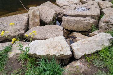 a pile of large rocks on a river bank