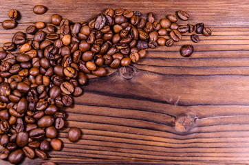 Pile of the roasted coffee beans on wooden table. Top view